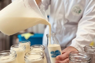 Pouring milk into a glass bottle