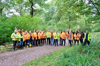 Group photo of people dressed in high vis in a woodland