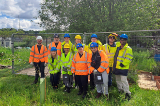 Group of volunteers in high vis smiling at camera in Westcott Garden