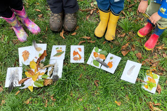 photo of children's feet in wellies around leaf pictures on the grass floor