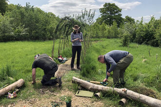 A woman and two men working in garden