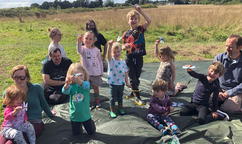 Children hold up their handmade dragonflies