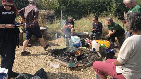 Group sit round a campfire