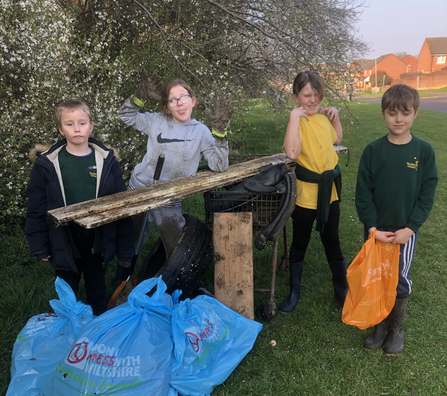 4 children pose with the rubbish they have collected from the river