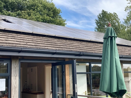 Solar panels on top of roof at Brockbank Centre, with table umbrella in the foreground