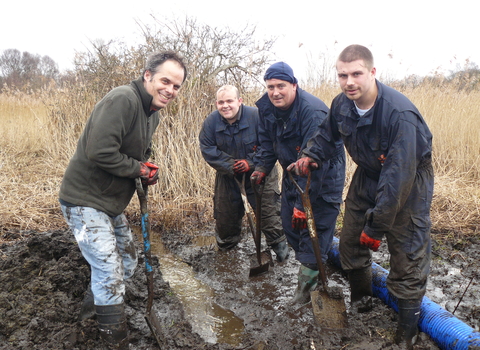 A group of friends dig in the mud