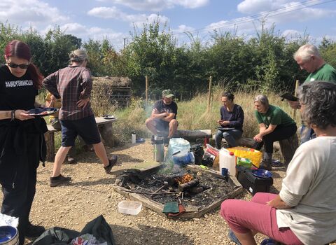 Group sit round a campfire